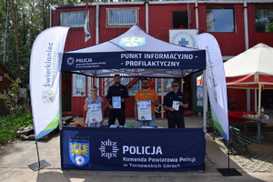 policjanci w mundurach wraz z przedstawicielami gminy Świerklaniec stojący w namiocie z napisami Punkt Profilaktyczno - Informacyjny, Komenda Powiatowa Policji w Tarnowskich Górach