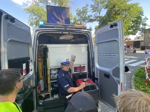 policjant prezentuje sprzęt w radiowozie
