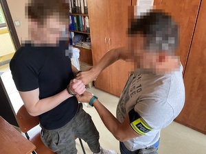 policjant rozpina kajdanki zatrzymanemu