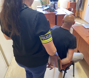 policjantka przy zatrzymanym w pomieszczeniu