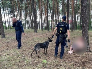policjanci wraz z psem służbowym