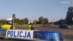 policyjny neon z napisem policja, w tle policjanci w mundurach