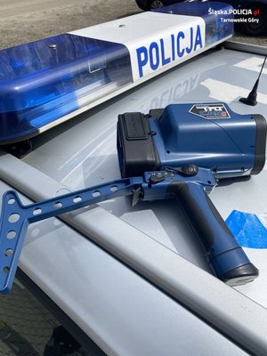 urządzenie do pomiaru prędkości przy policyjnym neonie z napisem policja
