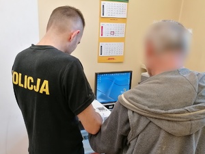 policjant pobierający odciski palców od zatrzymanego