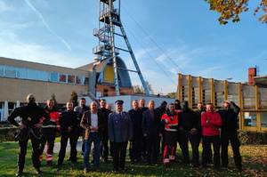 Policjanci podczas szkolenia z ratownikami CSRG. Zdjęcie grupowe uczestników. w tle budynek kopalni.