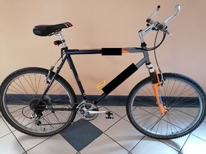 zdjęcie przedstawia rower pomarańczowo - szary