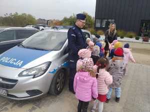 policjant pokazujący radiowóz