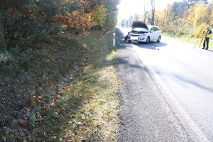 biały rozbity samochód stojący na drodze
