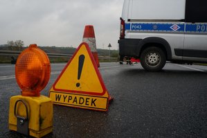 znak wypadek a w tle radiowóz