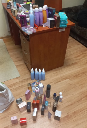 kosmetyki ułożone na biurku i ziemi w pomieszczeniu