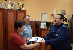 na zdjęciu komendanci wręczają listy gratulacyjne pracownikom cywilnym komendy