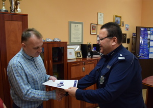 na zdjęciu komendanci wręczają listy gratulacyjne pracownikom cywilnym komendy