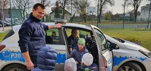 na zdjęciu policjanci prezentujący dzieciom policyjny radiowóz