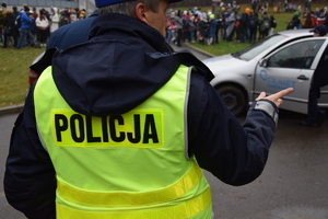 Na zdjęciu widoczny policjant w odblaskowej kamizelce.