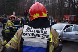 Na zdjęciu widoczny funkcjonariusz Straży Pożarnej kierujący działaniami ratowniczymi