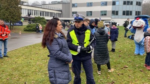 Na zdjęciu widoczny policjant, sznupek oraz uczestnicy wydarzenia.