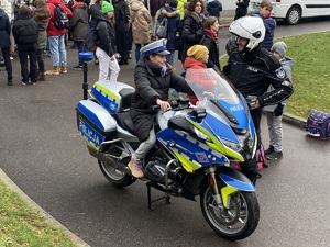 Na zdjęciu widoczny policjant oraz uczestniczka wydarzenia siedząca na policyjnym motocyklu