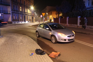 na zdjęciu samochód osobowy, obok niego rzeczy należące do potrąconej