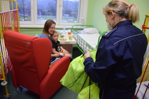 Na zdjęciu policjantka wręczająca upominek dziecku