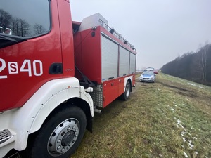 na zdjęciu wóz strażacki i policyjny radiowóz zaparkowane na wale zbiornika wodnego