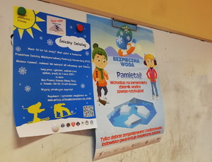 na zdjęciu kolorowe plakaty informujące o bezpieczeństwie podczas ferii, przywieszone na tablicy szkolnej