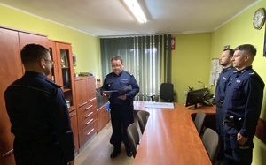na zdjęciu komendant powiatowy policji w trakcie odczytywania rozkazu, przed nim stoi nowy komendant komisariatu, a obok, za stołem, policjanci