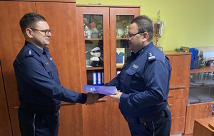 na zdjęciu komendant powiatowy gratuluje nowemu komendantowi komisariatu