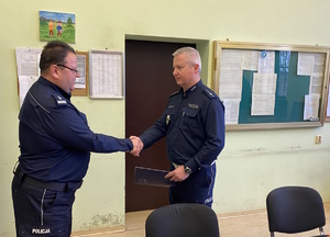 na zdjęciu komendant powiatowy policji w tarnowskich górach gratuluje nowemu zastępcy naczelnika wydziału ruchu drogowego w tarnowskich górach