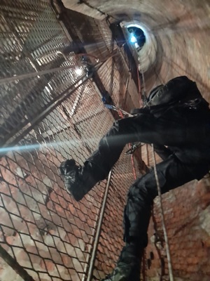 na zdjęciu policjant w trakcie ćwiczeń pod ziemią w górniczym szybie