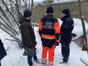 na zdjęciu policjant, ratownik medyczny i pracownik socjalny w trakcie sprawdzania miejsca przebywania osób bezdomnych