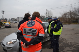 na zdjęciu policjanci w trakcie kontroli drogowej, obok stoi ratownik medyczny i przedstawiciel starostwa