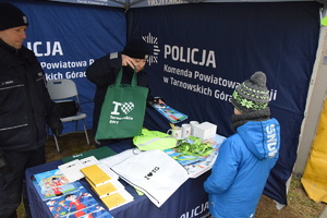 na zdjęciu policjant i policjantka w trackie rozmowy z dzieckiem