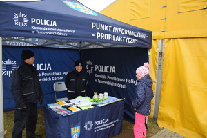 na zdjęciu policjant i policjantka w trackie rozmowy z dzieckiem