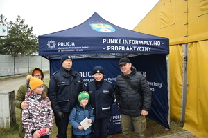 na zdjęciu policjanci wraz z dziećmi ich rodzicami przed namiotem informacyjnym