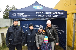 na zdjęciu policjanci wraz z dziećmi ich rodzicami przed namiotem informacyjnym