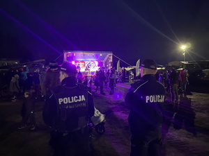 na zdjęciu policjanci a w tle scena i ludzie