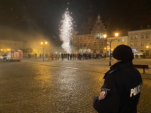 na zdjęciu policjant obserwuje pokaz fajerwerków na płycie rynku w tarnowskich górach