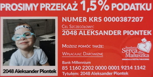 plakat z czerwonym, w górnej części napis &lt;przekaż 1,5% podatku&gt;, w lewej części grafiki znajduje się wizerunek dziecka w okularach, dziecko jest w białej koszulce, w tle widoczna posadzka i meble. W centralnej części plakatu znajdują się informacje związane z możliwością przekazania 1,5% podatku, tj. nr krajowego rejestru sądowego oraz celu szczegółowego. Poniżej znajduje się numer konta do wpłat darowizn oraz tytuł przelewu. W prawej części plakatu znajduje się białe serce, nad którym widoczna jest animowana głowa dziecka. Po lewej stronie serca znajduje się napis: &lt;fundacja serce dla maluszka organizacja pożytku publicznego&gt;