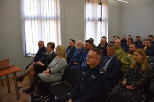 na zdjęciu zaproszeni goście oraz policjanci siedzący na krzesłach w sali narad w trakcie odprawy