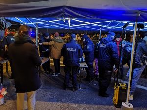na zdjęciu policjanci w jednym z namiotów, gdzie przeprowadzają kontrole osób przybyłych na spotkanie