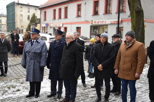 na zdjęciu osoby stojące na chodniku, wśród których znajduje się komendant powiatowy policji i dyrektor aresztu śledczego