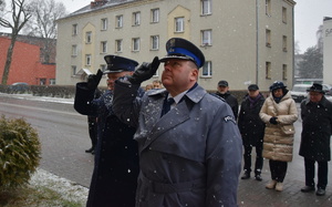 na zdjęciu komendant powiatowy policji i dyrektor aresztu w trakcie oddawania honoru przy tablicy pamiątkowej wmurowanej w budynek komendy policji