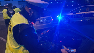 na zdjęciu policjant badający trzeźwość kierującego