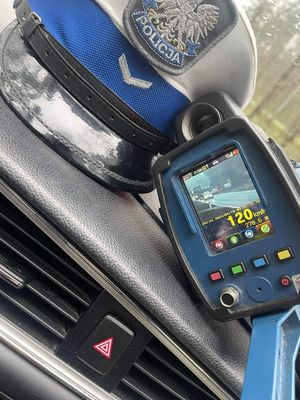 Na zdjęciu widoczny fotoradar wraz z czapką policjanta ruchu drogowego