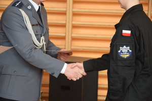 Na zdjęciu widoczny policjant gratulujący uczniowi