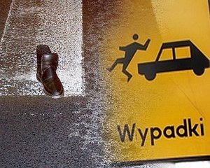na zdjęciu fragment przejścia dla pieszych, na którym leży but, obok znak drogowy "wypadki"