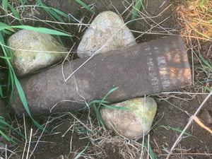 na zdjęciu pocisk otoczony kamieniami