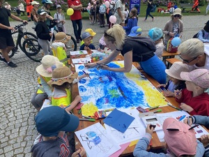 na zdjęciu dzieci przy stole, w trakcie malowania swojego dzieła