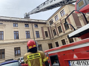 na zdjęciu drabina strażacka w trakcie działań przy dachu urzędu, obok strażak