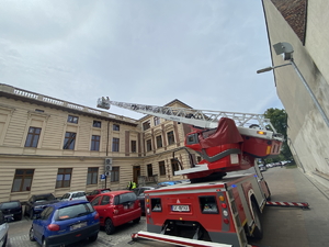 panoramiczne zdjęci wozu strażackie z rozciągniętą drabiną nad pojazdami w trakcie akcji ratunkowej
